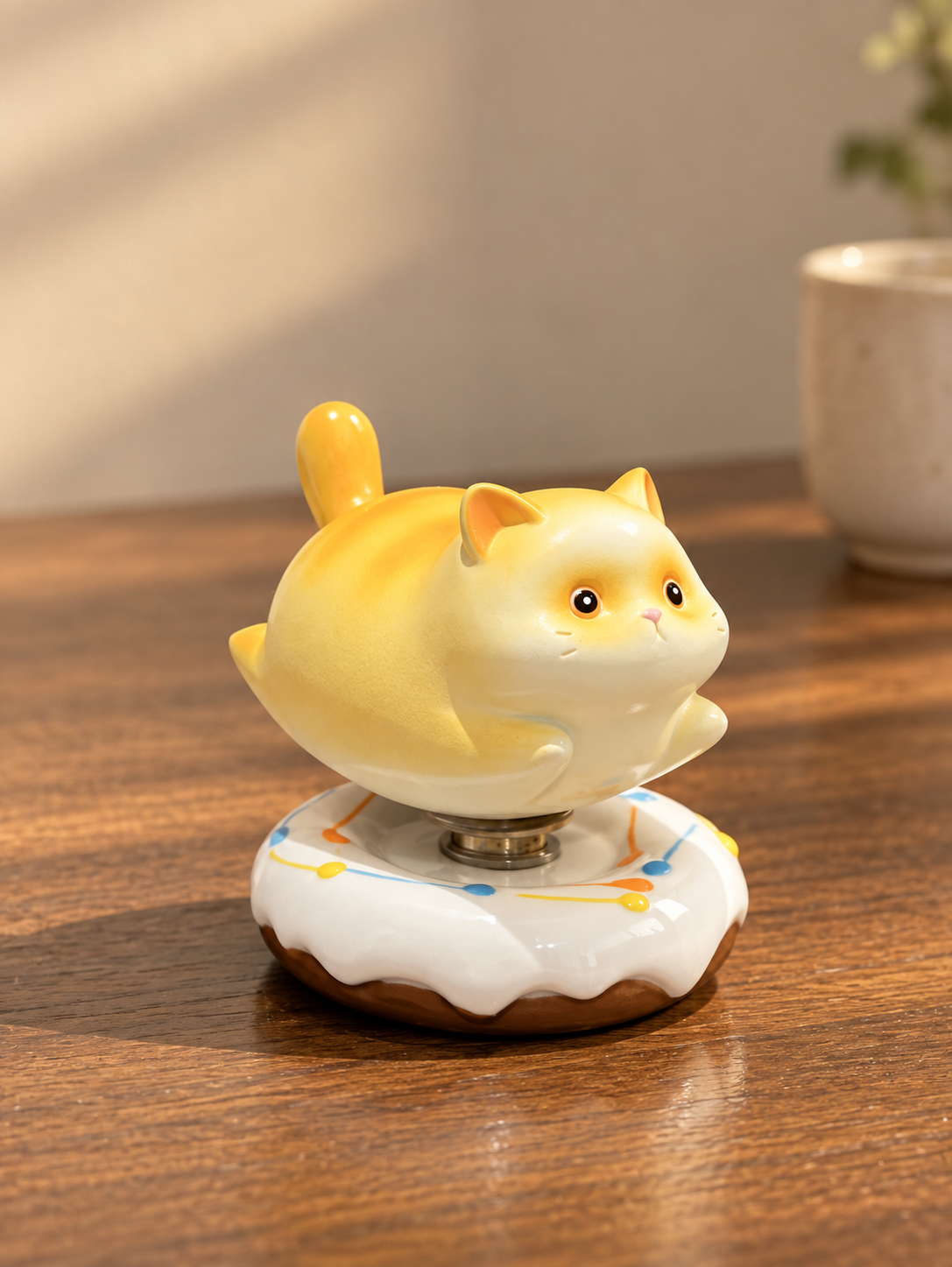 Yellow cat-shaped ceramic ornament on a white floral base