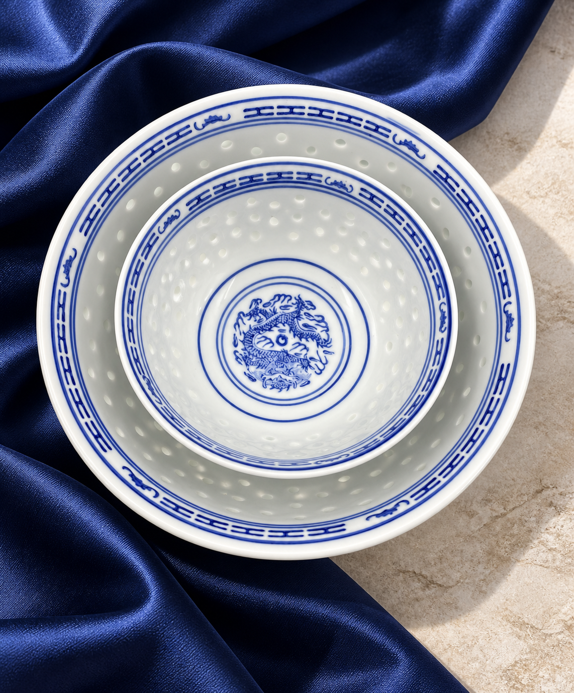 Blue and white patterned porcelain bowls viewed from above on blue fabric