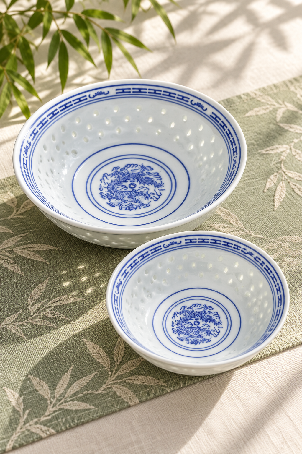 Two blue and white porcelain bowls with patterned rims on a light tablecloth