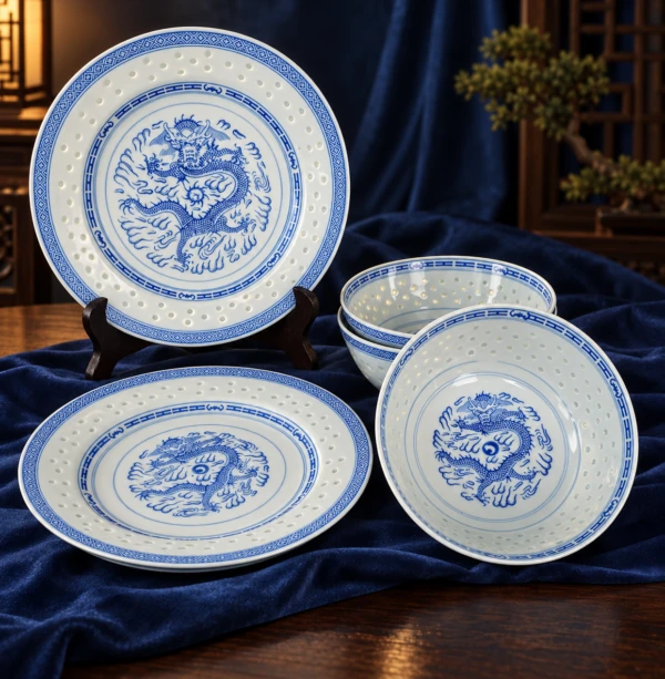 Blue and white dragon-pattern bowls and plates displayed on dark blue fabric