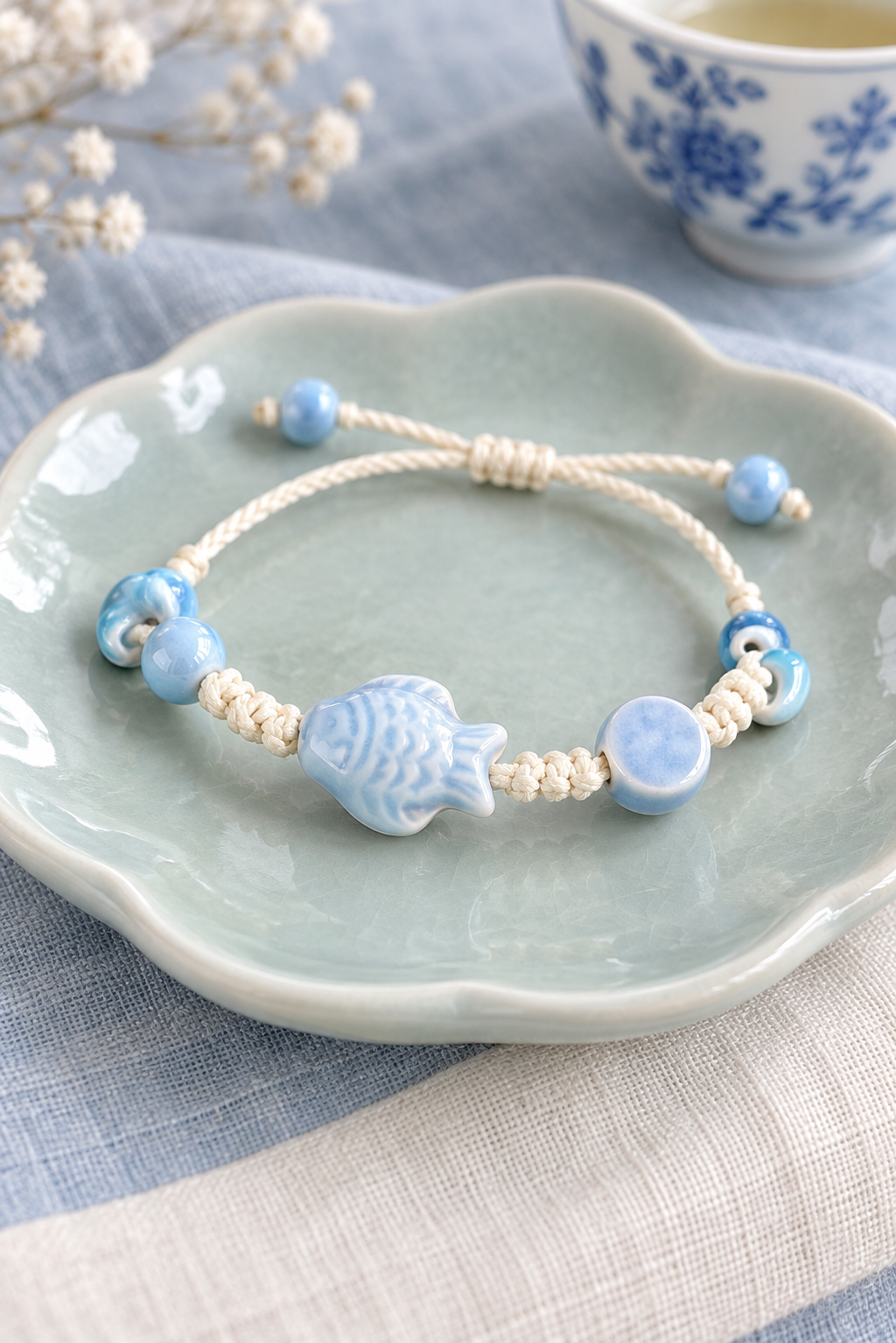 Pale blue fish ceramic bracelet with cream knotted adjustable cord